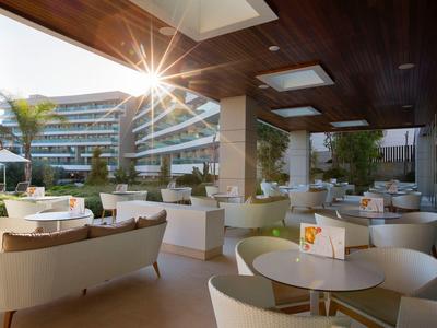 Elegante area salotto all'aperto dell'hotel con tramonto e arredamento moderno.