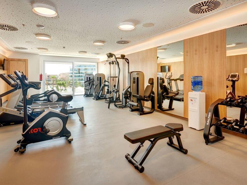 Palestra moderna con attrezzature varie e luce naturale.