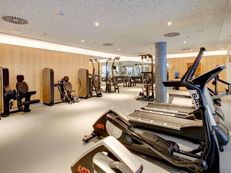 Palestra moderna con tapis roulant e attrezzature per allenamento vario.