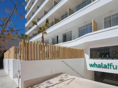 Complesso alberghiero moderno con balconi e ingresso Whalafun visibile in una zona soleggiata.