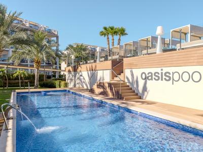 Espace piscine bleu clair avec terrasse ensoleillée et palmiers par temps ensoleillé