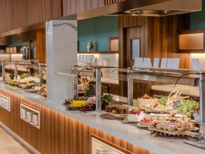 Buffet avec divers plats et éclairage chaud dans un espace intérieur moderne.