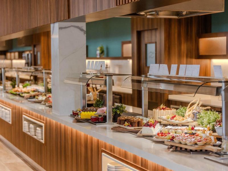 Buffet avec divers plats et éclairage chaud dans un espace intérieur moderne.