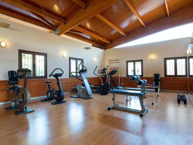 Lichte, gezellige fitnessruimte met houten plafond en ramen.