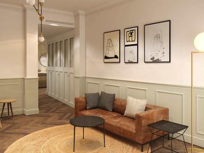 Accogliente area lounge dell'hotel con divano in pelle marrone, tavoli e quadri decorativi.