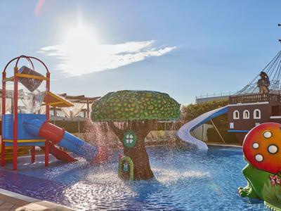 Vodní park s barevnými skluzavkami a sochami hub v hotelovém bazénu za slunečného dne