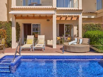 Terasa s lehátky a kulatou pohovkou vedle soukromého bazénu v rekreačním objektu