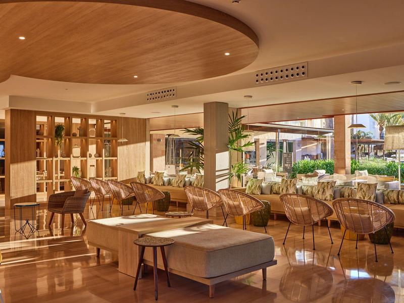 Moderní hotelová lobby s pohodlnými křesly a dřevěnými prvky.