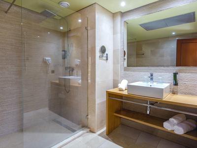 Moderne Badezimmer mit Glasdusche, rechteckigem Waschbecken, Holzregal und großen Spiegel.