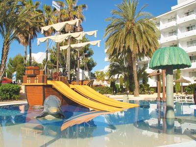 Kolorowy plac zabaw wodnych ze zjeżdżalniami i palmami przy budynku hotelu.