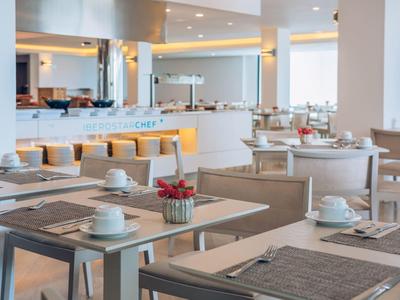 Modernes Restaurant mit hellen Holzmöbeln, gedeckten Tischen und gemütlicher Beleuchtung.