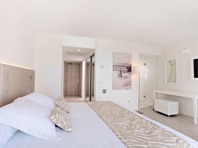 Helles, modernes Schlafzimmer mit weißer Einrichtung, Doppelbett, Teppich und Wandbild.