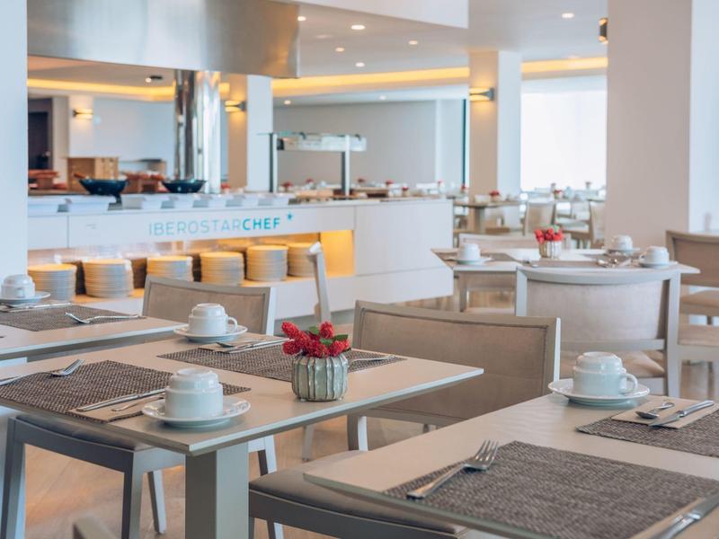 Modernes Restaurant mit hellen Holzmöbeln, gedeckten Tischen und gemütlicher Beleuchtung.