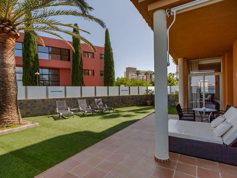 Area giardino moderna con lettini e terrazza accogliente in un hotel.