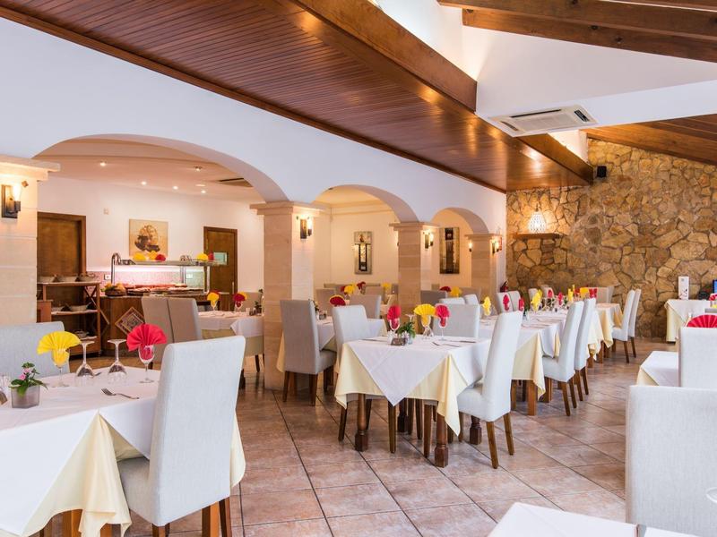 Ristorante luminoso con sedie bianche e tavoli apparecchiati in un ambiente accogliente.