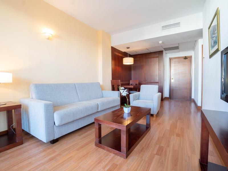 Soggiorno moderno con divano, poltrona, pavimento in legno e TV.