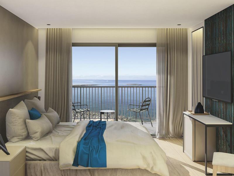 Nowoczesny pokój hotelowy z widokiem na morze, łóżko podwójne, balkon i przytulne wnętrze.