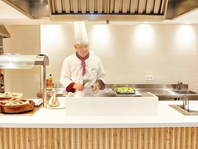 Kucharz przygotowuje świeże składniki w nowoczesnej kuchni hotelowej.