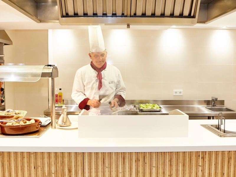 Kucharz przygotowuje świeże składniki w nowoczesnej kuchni hotelowej.