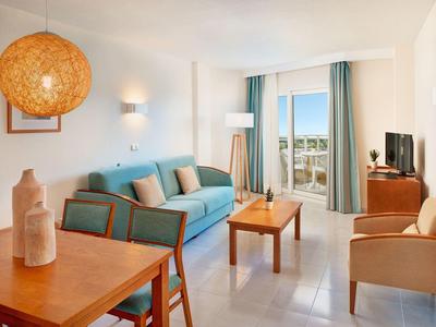 Soggiorno luminoso con divano, poltrone e balcone con vista sul mare.