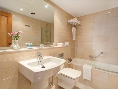 Bagno moderno con lavabo, toilette, vasca da bagno e specchio.