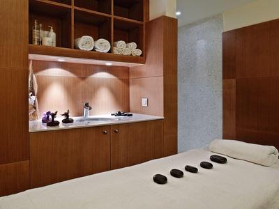 Una stanza spa rilassante con un lettino da massaggio e pietre calde.