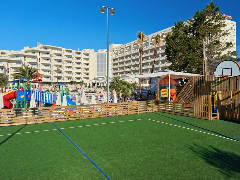 Hotel con campo da calcio all'aperto, struttura per arrampicata e piscina sotto un cielo sereno.