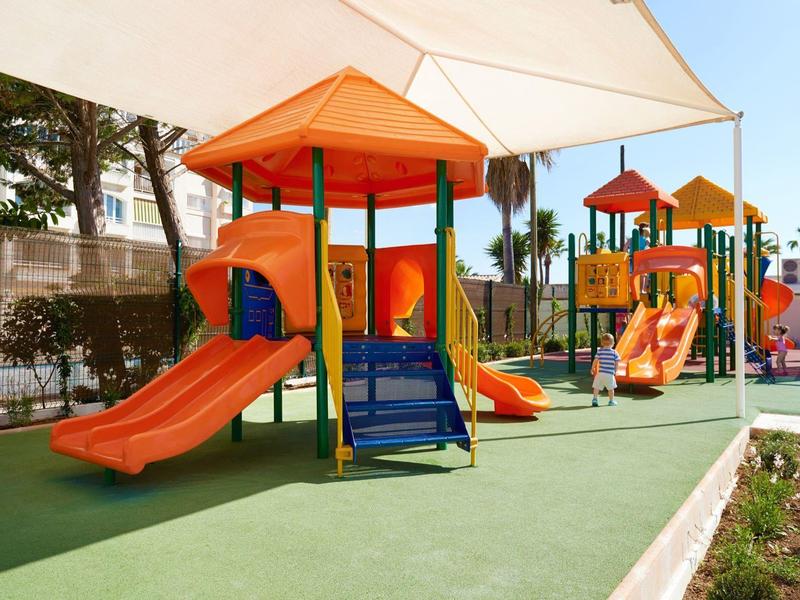 Colorato parco giochi all'aperto con scivoli e strutture per arrampicarsi.