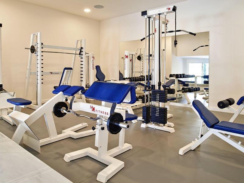 Palestra moderna con vari attrezzi e imbottiture blu.