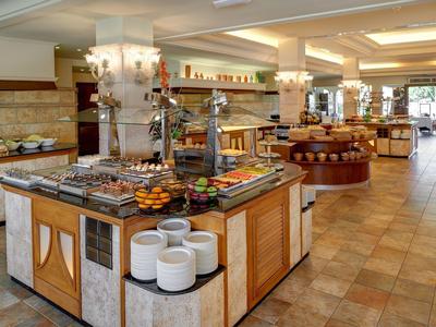 Ruim buffetgedeelte in een hotel met diverse eetbar en warme verlichting.