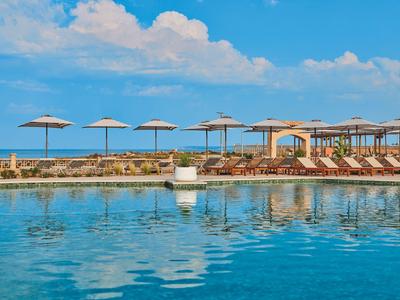 Area piscina con lettini e ombrelloni vicino al mare in una giornata di sole