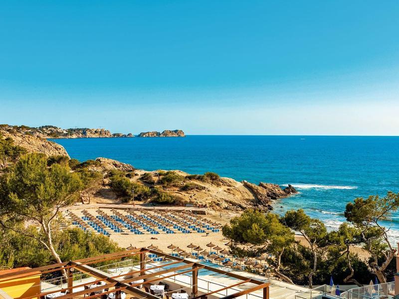 Plaża z leżakami i parasolami na skalistym wybrzeżu pod czystym niebem