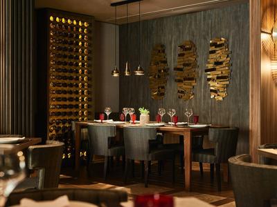 Elegantes Restaurant mit Holzwänden, modernem Weinregal und stilvoll gedeckten Tischen.