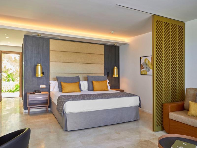 Modern eingerichtetes Hotelzimmer mit großem Bett und gemütlicher Sitzecke.