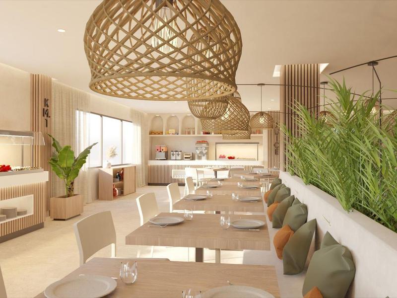 Restaurante luminoso con grandes ventanas, áreas de estar acogedoras y decoración natural.