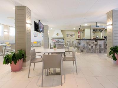 Nowoczesny bar hotelowy i restauracja z stołami, krzesłami i stylowym wystrojem.