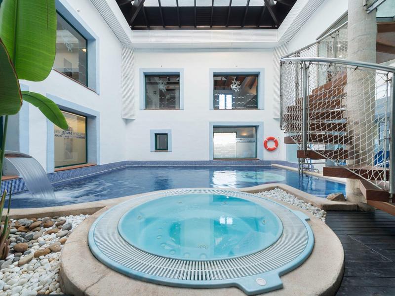 Nowoczesna kryta część basenu z jacuzzi i szklanym dachem w hotelu.
