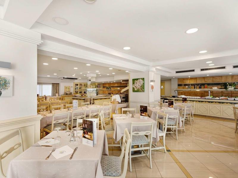 Restaurant d'hôtel lumineux et moderne avec de nombreuses tables et chaises, propre et accueillant.