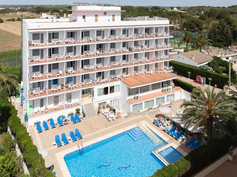 Mehrstöckiges Hotel mit Pool, Sonnenliegen und grüner Umgebung an sonnigem Tag.
