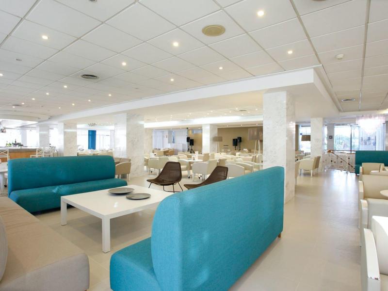 Area lounge dell'hotel luminosa con gruppi di posti a sedere e sedie moderne.