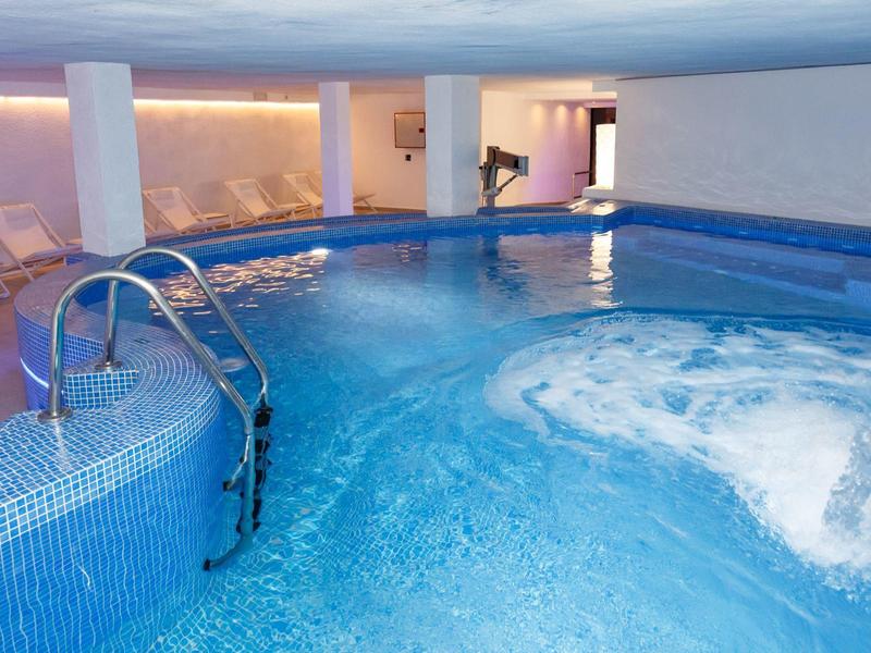 Verwarmd binnenzwembad met watermassage en zitplaatsen in een hotel