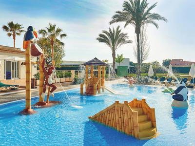 Buntes Kinder-Schwimmbecken mit Wasserspielen, Palmen, Rutschen und Spielgeräten im Freien.