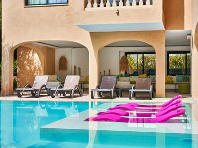 Zwembadgedeelte met ligstoelen en zwembadaccessoires voor een hotelgebouw