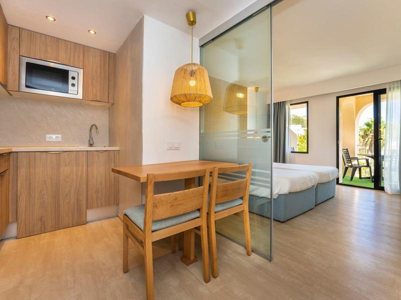 Moderne hotelkamer met kitchenette, eethoek en balkon met zeezicht