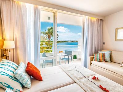 Gemütliches Doppelzimmer mit großen Fenstern, Balkon und Meerblick, hell und modern eingerichtet.