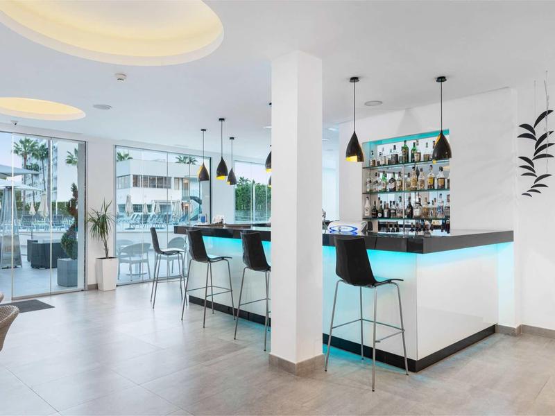 Jasny bar z nowoczesnymi stołkami w jasnej i przestronnej przestrzeni hotelowej.