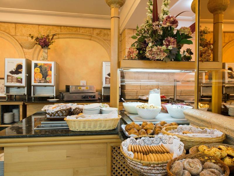 Buffet with assorted pastries and breakfast items in an elegant hotel dining area.