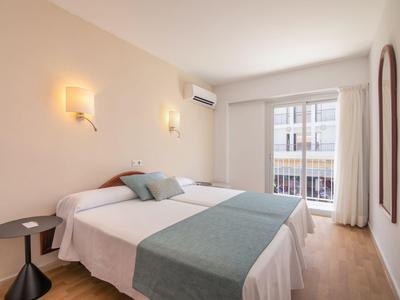 Camera moderna con letto matrimoniale, due piccoli tavoli e balcone con ringhiera