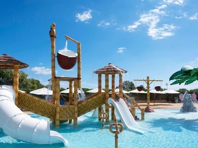 Parco acquatico con scivoli e piscina sotto un cielo sereno.