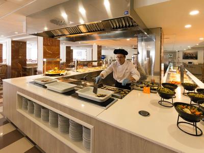 Cucina moderna aperta con uno chef che prepara piatti in un hotel.